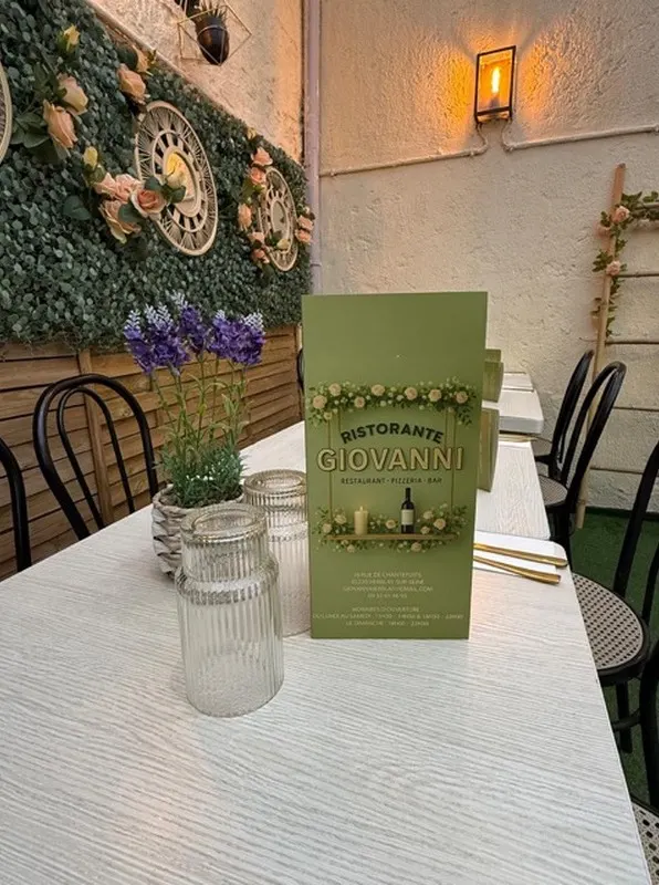 Table dressée devant un mur végétal et des horloges anciennes