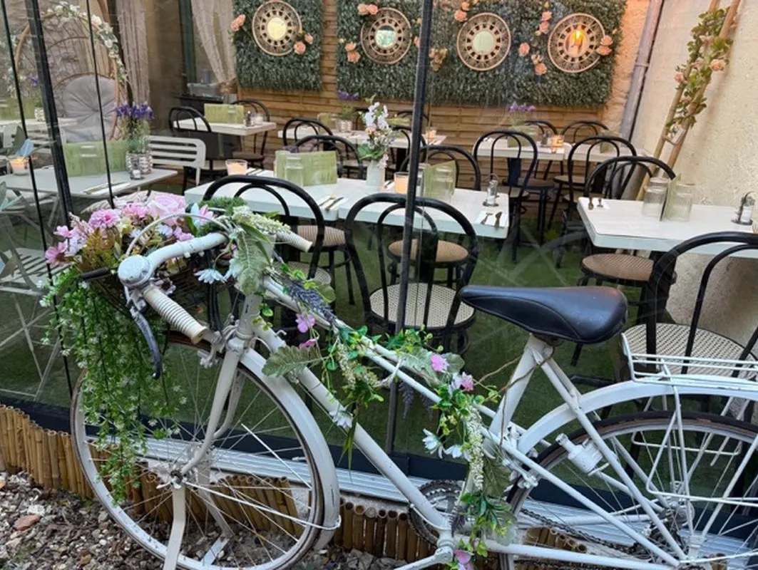 Vieux vélo couvert de fleurs devant la terrasse